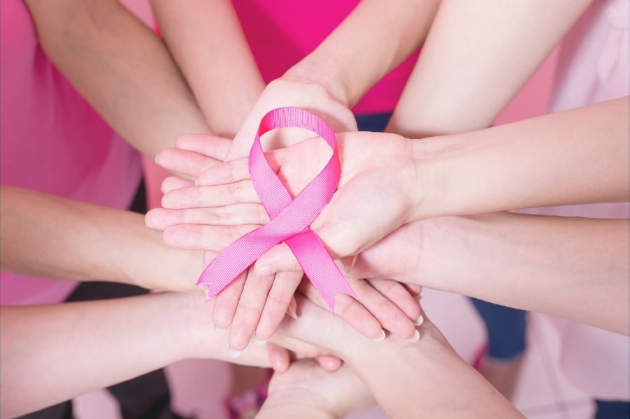 Mani con nastro rosa per il convegno sul tumore mammario metastatico a Pisa presso Casa di Cura San Rossore.